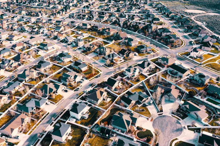 High-angle aerial shot of a suburban neighborhood in Herriman, Utah showcasing residential architecture and streets.